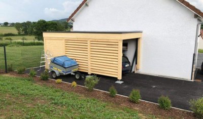 Création et pose d'abris de voiture avec rangement ou local à moto à Besançon et ses environs.
